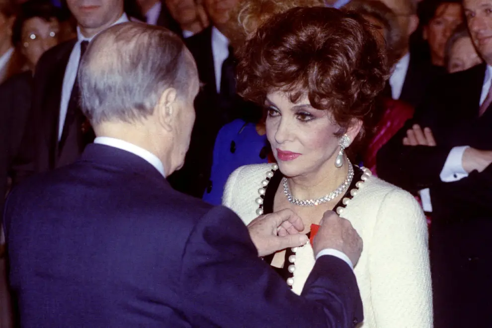 El presidente francés François Mitterrand impone a la actriz italiana Gina Lollobrigida el emblema de la Legión de Honor.