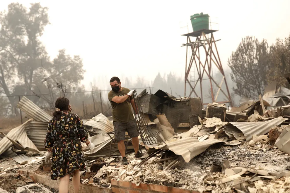 Local residents inspect the remains of a burnt house, as a wildfire burned parts of rural areas in Santa Juana, near Concepcion, Chile, February 4, 2023. REUTERS/Juan Gonzalez CHILE-FIRE/
