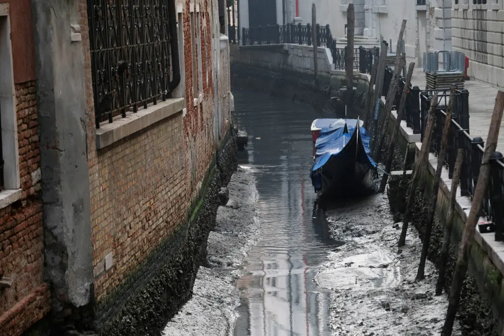 A gondola is pictured in a canal during a severe low tide in the lagoon city of Venice, Italy, February 17, 202. REUTERS/Manuel Silvestri EUROPE-WEATHER/ITALY-DROUGHT