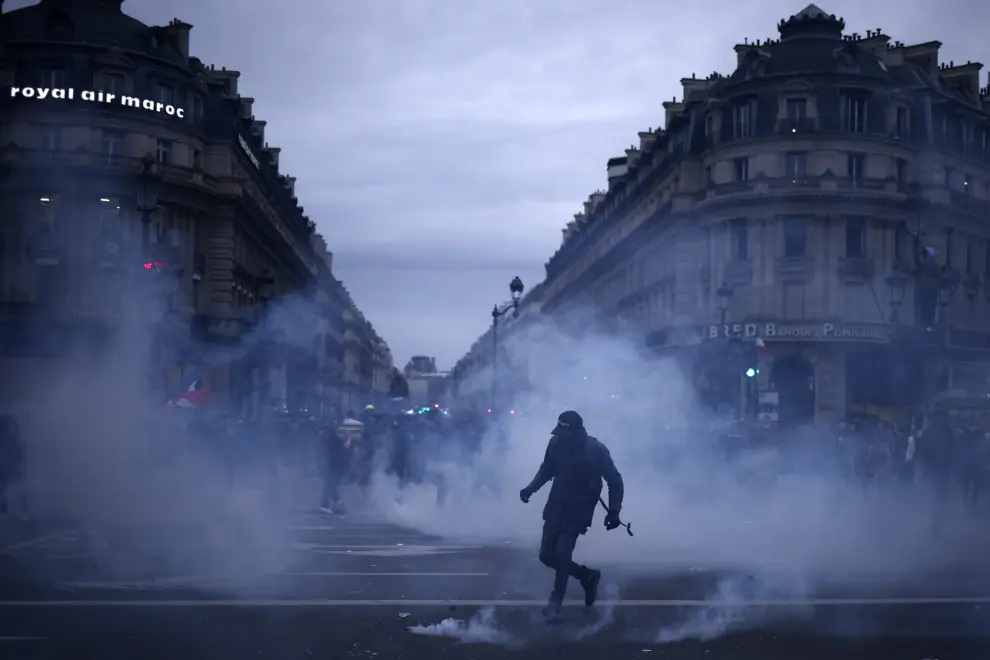 Paris (France), 23/03/2023.- Protesters stands in tear gas fumes during clashes with anti-riot police at Opera square as thousands of people participate in a protest against the government's reform of the pension system in Paris, France, 23 March 2023. Protests continue in France after the prime minister announced on 16 March 2023 the use of Article 49 paragraph 3 (49.3) of the French Constitution to have the text on the controversial pension reform law - raising retirement age from 62 to 64 - be definitively adopted without a vote. (Protestas, Francia, Estados Unidos) EFE/EPA/YOAN VALAT
 FRANCE PENSIONS PROTEST