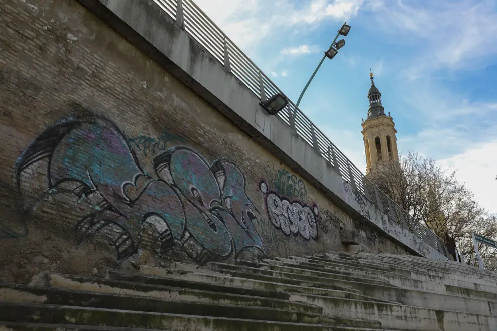 Los grafitis se ceban con comercios, viviendas y hasta monumentos como el puente de Piedra o la Seo.