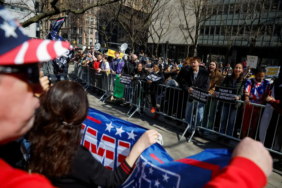 A flag in support of  former U.S. President Donald Trump is waved outside Manhattan Criminal Courthouse on the day of his planned court appearance after his indictment by a Manhattan grand jury following a probe into hush money paid to porn star Stormy Daniels, in New York City, U.S., April 4, 2023. REUTERS/Amanda Perobelli USA-TRUMP/