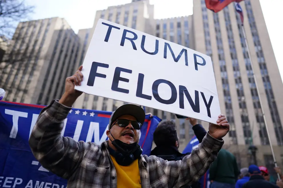 A supporter of former U.S. President Donald Trump holds a sign outside the Trump Tower on the day of Trump's planned court appearance after his indictment by a Manhattan grand jury following a probe into hush money paid to porn star Stormy Daniels, in New York City, U.S., April 4, 2023. REUTERS/Carlos Barria USA-TRUMP/