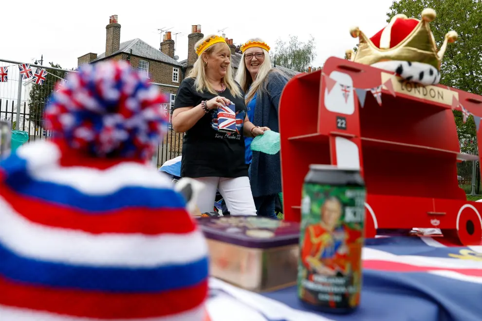 A woman places a beer can with the picture of Britain's King Charles on it, as she sets up a table during a picnic at Windsor Castle, in Windsor, Britain May 7, 2023. REUTERS/Stephanie Lecocq BRITAIN-ROYALS/CORONATION