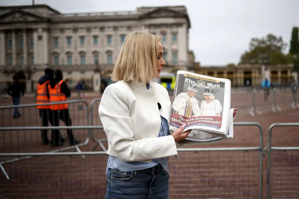 British newspaper front pages are seen on the pavement next to Maja Wojcikowska, TVN24 television reporter from Poland, outside Buckingham Palace, the day after Britain's King Charles' coronation, in London, Britain May 7, 2023. REUTERS/Henry Nicholls BRITAIN-ROYALS/CORONATION