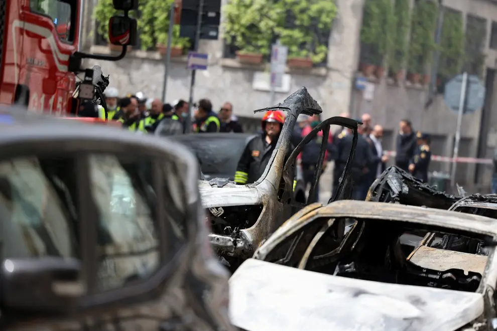 A firefighter stands next to a burnt vehicle following an explosion in the centre of Milan, Italy, May 11, 2023. REUTERS/Claudia Greco ITALY-EXPLOSION/