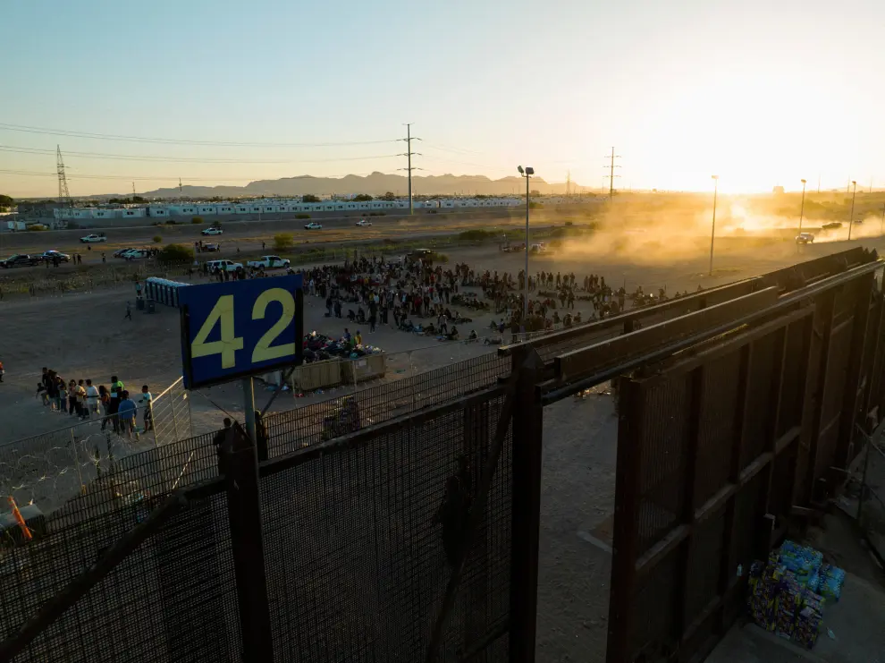 Migrants stand near Border Gate 42 along the border highway in El Paso, Texas