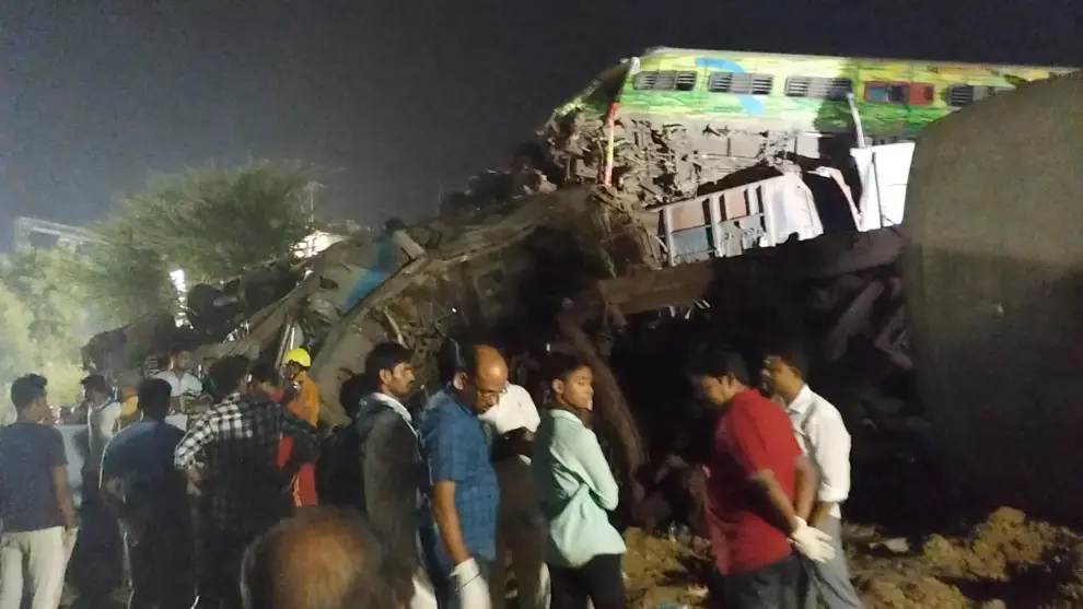 People stand next to damaged coaches, after trains collided in Balasore, India June 3, 2023, in this picture obtained from social media. Nantu Samui/via REUTERS  THIS IMAGE HAS BEEN SUPPLIED BY A THIRD PARTY. MANDATORY CREDIT. NO RESALES. NO ARCHIVES. INDIA-CRASH/RAIL