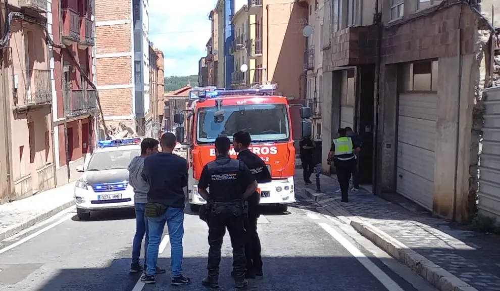 A la izquierda, la casa de cinco plantas que ha colapsado tras ser evacuadas 21 viviendas en Teruel.