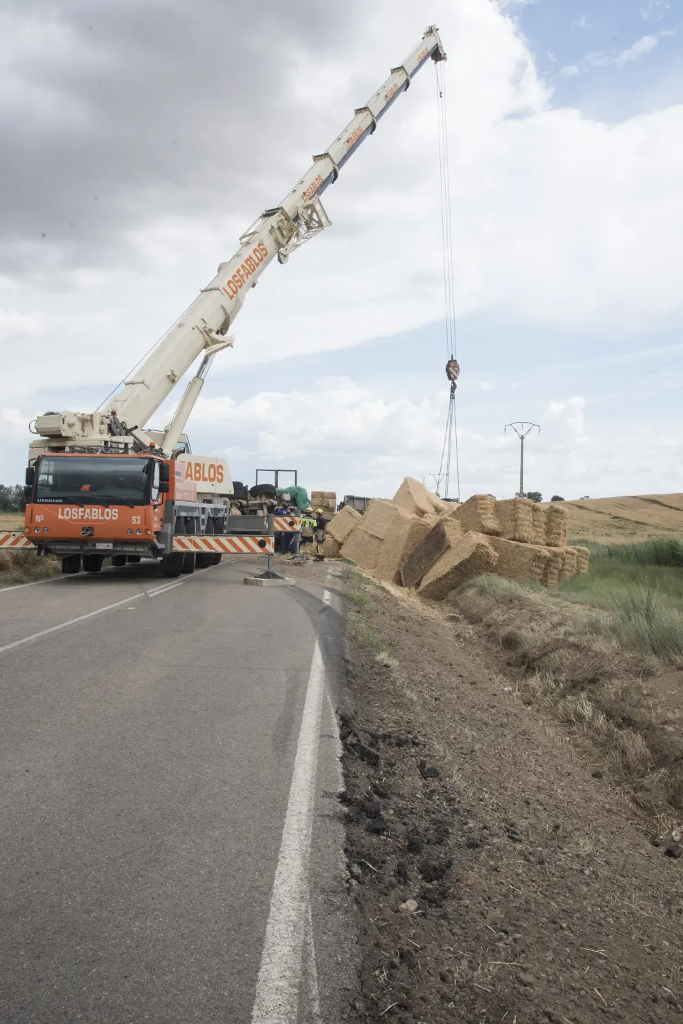 Accidente de un camión cargado de pacas de paja en la A-1212, entre Huesca y Sangarrén.