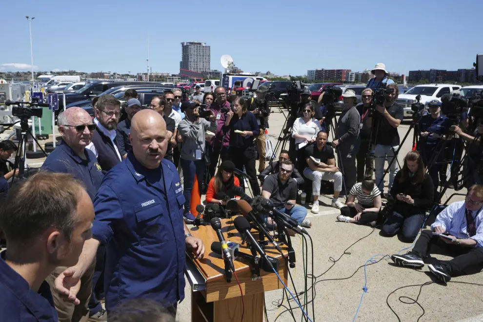 U.S. Coast Guard Capt. Jamie Frederick, center left at microphone, faces reporters during a news conference, Wednesday, June 21, 2023, at Coast Guard Base Boston, in Boston. A Canadian surveillance vessel has detected more underwater noises in the area where rescuers are searching for a submersible that went missing in the North Atlantic while bringing five people down to the wreck of the Titanic, authorities said Wednesday. (AP Photo/Steven Senne)