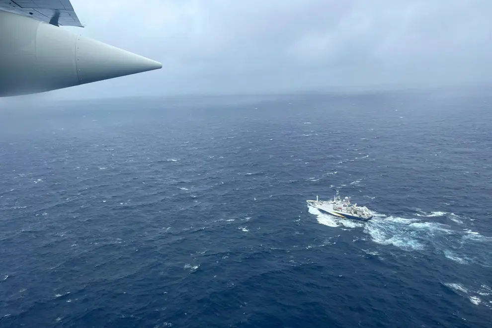 In this image provided by the U.S. Coast Guard, a Coast Guard HC-130 Hercules airplane based at Coast Guard Air Station Elizabeth City, N.C., flies over the French research vessel, L'Atalante approximately 900 miles East of Cape Cod, Mass., during the search for the 21-foot submersible, Titan, Wednesday, June 21, 2023. (U.S. Coast Guard via AP)