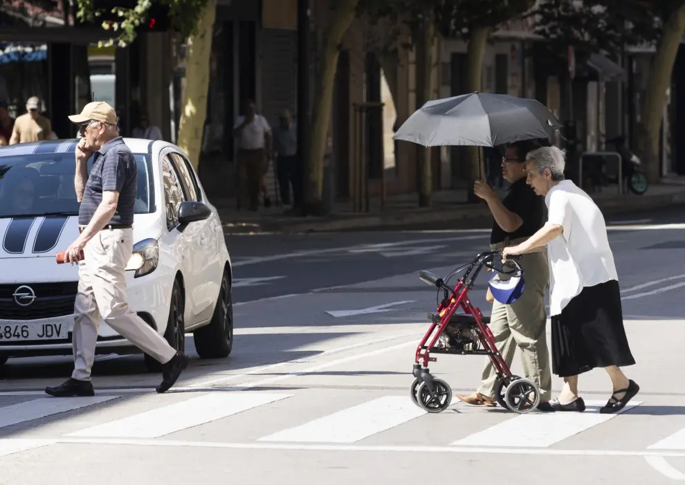 Personas mayores con paraguas protegiéndose del sol en Zaragoza