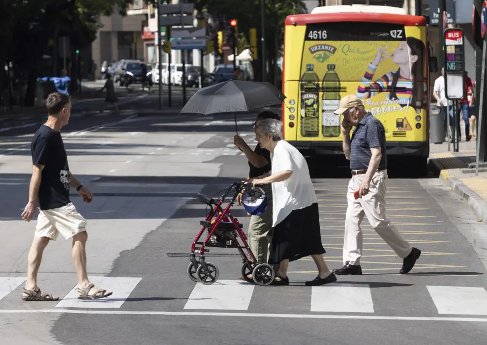Personas mayores con paraguas protegiéndose del sol en Zaragoza