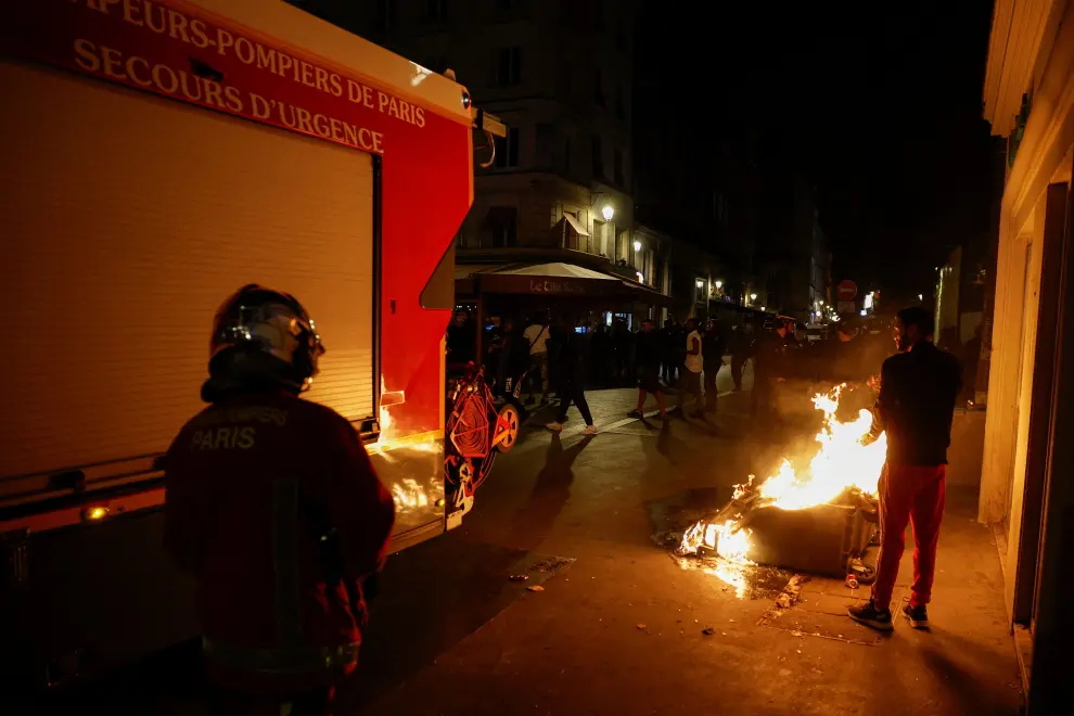 Firefighters work to extinguish a burning container as unrest continues following the death of Nahel, a 17-year-old teenager killed by a French police officer in Nanterre during a traffic stop, and against police violence, in Paris, France, July 1, 2023. REUTERS/Juan Medina FRANCE-SECURITY/SHOOTING