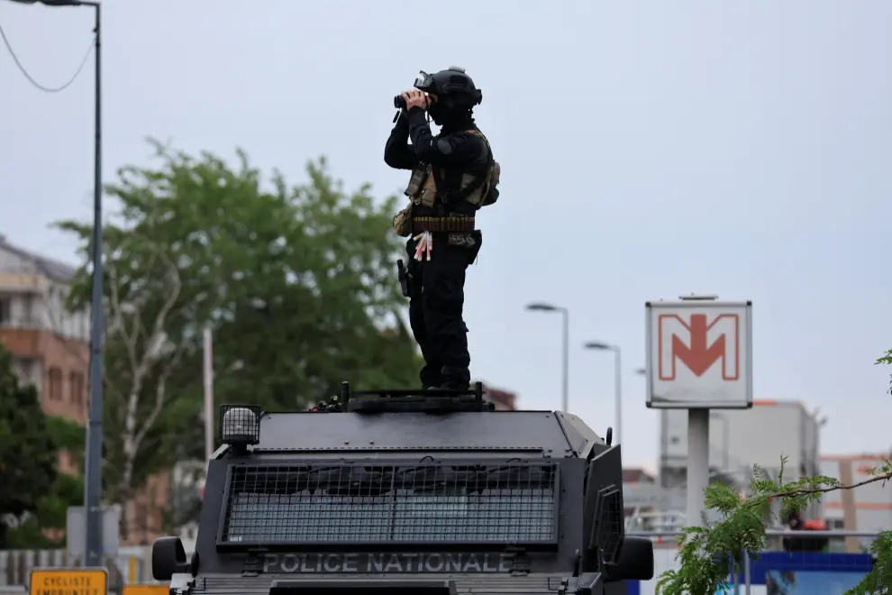 A French Recherche Assistance Intervention Dissuasion (RAID) special police unit member stands on his armoured car and uses his binoculars to check a protest following the death of Nahel, a 17-year-old teenager killed by a French police officer in Nanterre during a traffic stop, in Lille, France, 30 June 2023. REUTERS/Pascal Rossignol FRANCE-SECURITY/SHOOTING