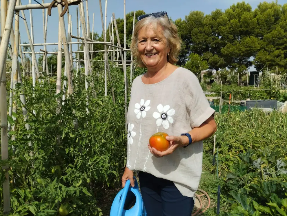 Lola San Miguel, con un tomate recién cogido, en el huerto que tiene alquilado en el Hortal del Canal, en Zaragoza.
