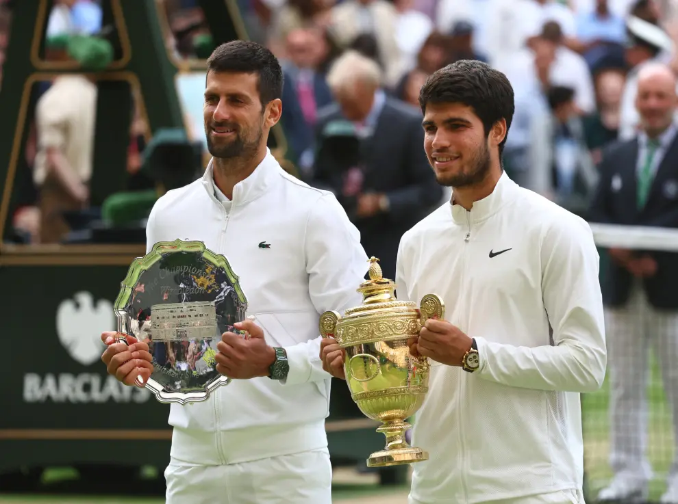 Tennis - Wimbledon - All England Lawn Tennis and Croquet Club, London, Britain - July 16, 2023 Spain's Carlos Alcaraz poses with the trophy after winning his final match alongside runner up Serbia's Novak Djokovic REUTERS/Toby Melville