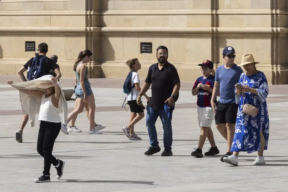 Varias personas paseando por la plaza del Pilar durante un día de calor extremo.