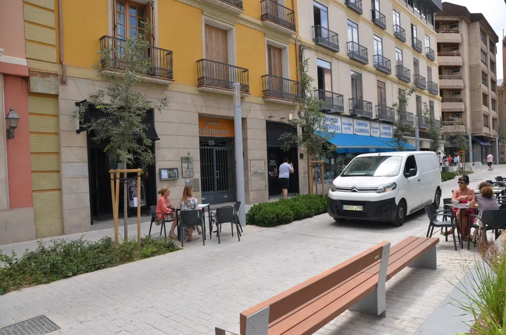 Una furgoneta, pasando en dirección prohibida entre las dos zonas de terraza adjudicadas al restaurante.