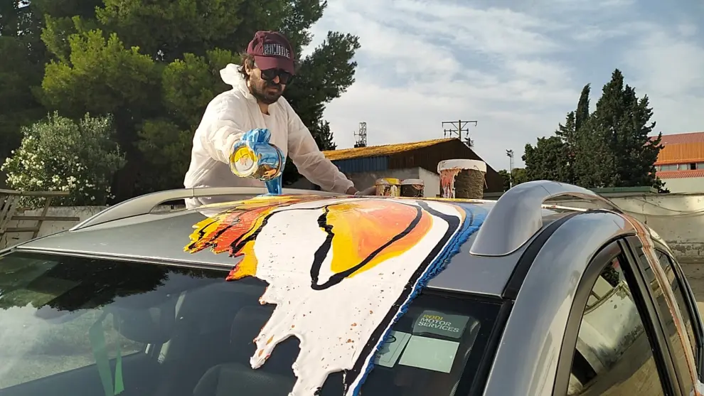 Fotos del pintor José Moñú con la obra que remata un coche en marcha