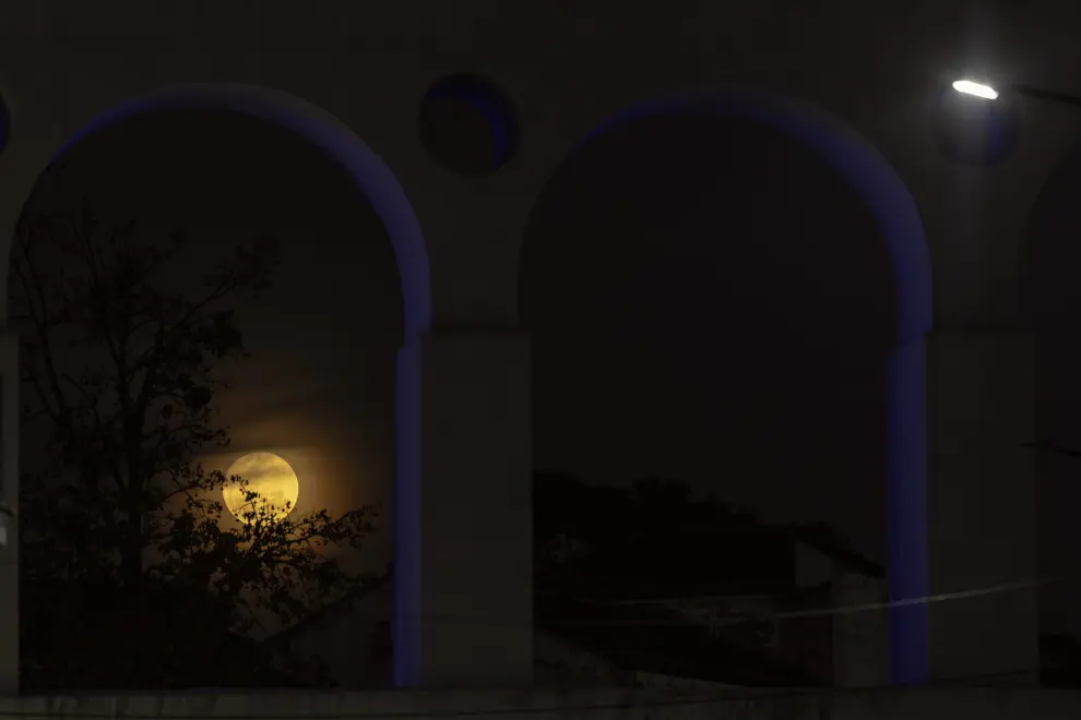 Fotografía que muestra la primera superluna de agosto emergiendo sobre los Arcos de la Lapa hoy en Río de Janeiro (Brasil).