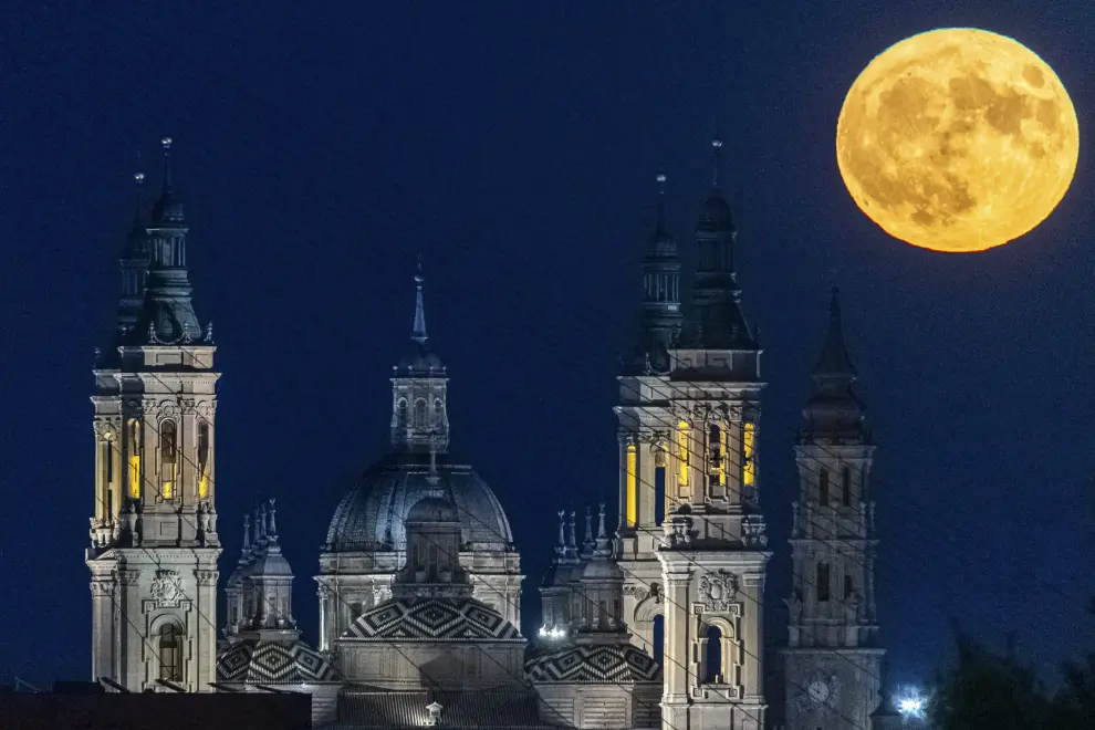 Vista de la primera superluna de agosto emergiendo sobre la Basílica del Pilar, en Zaragoza.