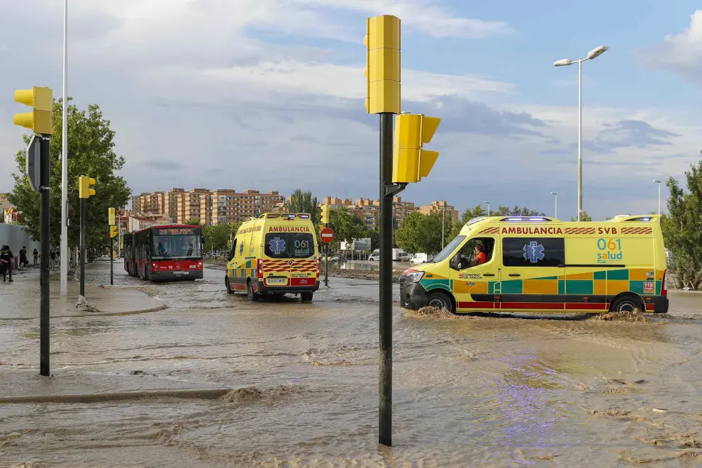 Dos ambulancias circulan por una carretera anegada de agua