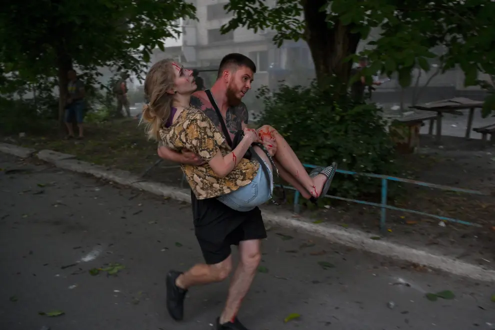 Pokrovsk (Ukraine), 07/08/2023.- An injured woman and a man observe rescue works at a site where a rocket hit the city of Pokrovsk, Donetsk area, Ukraine, 07 August 2023, amid the Russian invasion. At least five people died and 31 were injured after two rockets hit a residential building and a hotel downtown, according to a National Police report. Russian troops entered Ukrainian territory in February 2022, starting a conflict that has provoked destruction and a humanitarian crisis. (Rusia, Ucrania) EFE/EPA/STANISLAV KRUPAR UKRAINE RUSSIA CONFLICT