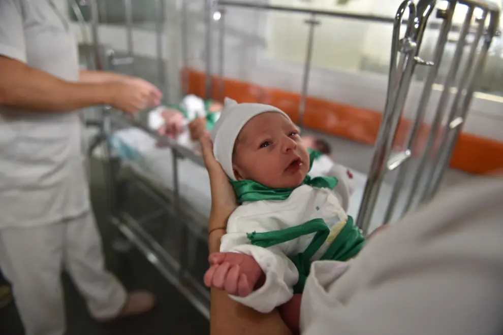 Los niños nacidos en San Lorenzo 2023 de la peña del Chupetín y el personal del Hospital San Jorge que los ha atendido.