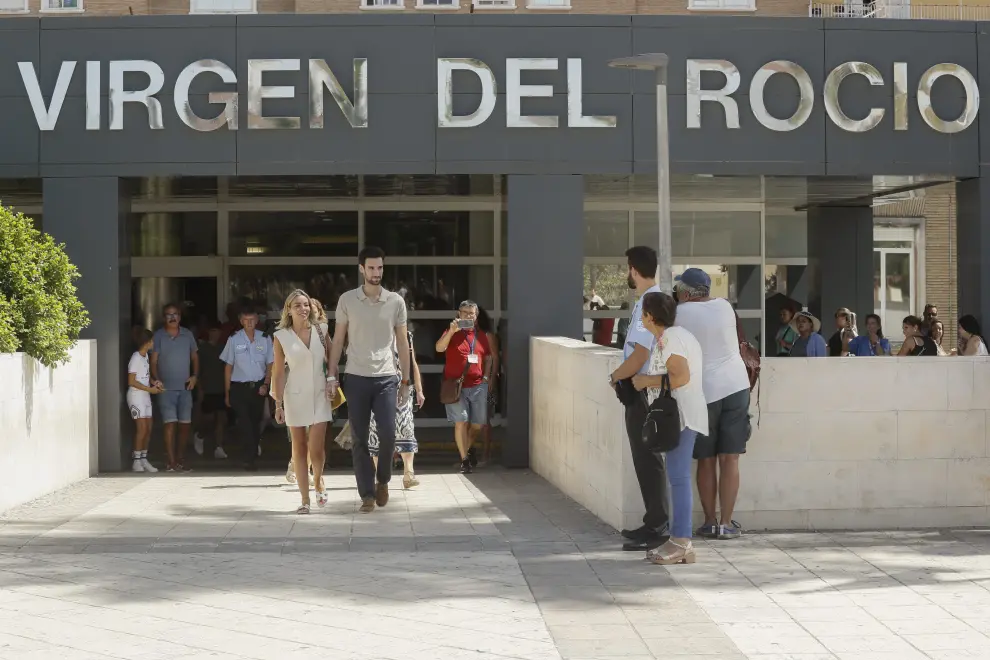 El portero sevillano del Paris Saint-Germain, Sergio Rico (d), abandona el hospital Virgen del Rocío en Sevilla junto a su mujer Alba Silva