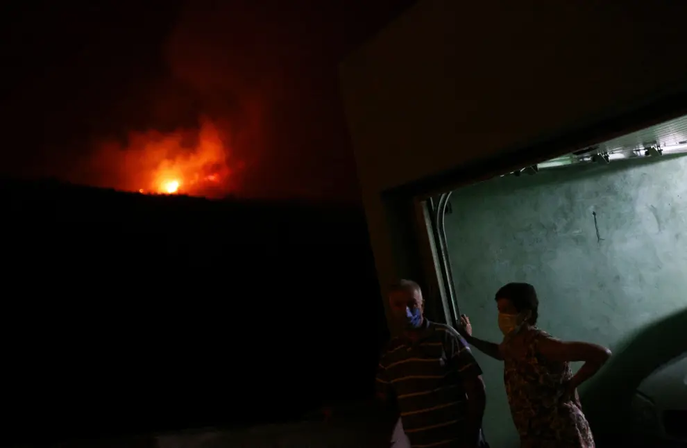 Samuel, 34, uses binoculars in the village of La Victoria, as wildfires rage out of control on the island of Tenerife, Canary Islands, Spain August 19, 2023. REUTERS/Nacho Doce EUROPE-WEATHER/SPAIN-WILDFIRES