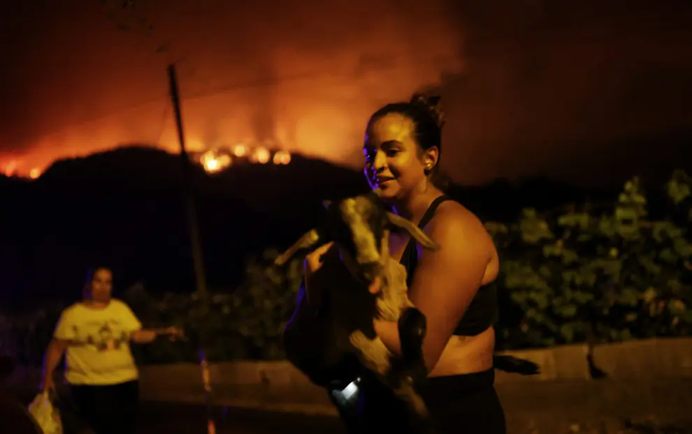 Manuel, 71, and his wife Rosa Maria, 68, stand at entrance of their house in the village of La Victoria, as wildfires rage out of control on the island of Tenerife, Canary Islands, Spain August 19, 2023. REUTERS/Nacho Doce EUROPE-WEATHER/SPAIN-WILDFIRES