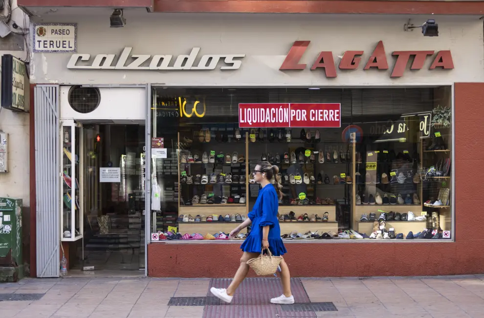Una mujer pasa por el escaparate de Calzados Lagatta, este miércoles en el paso de Teruel de Zaragoza