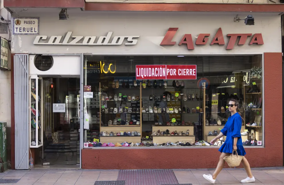 Una mujer pasa por el escaparate de Calzados Lagatta, este miércoles en el paso de Teruel de Zaragoza