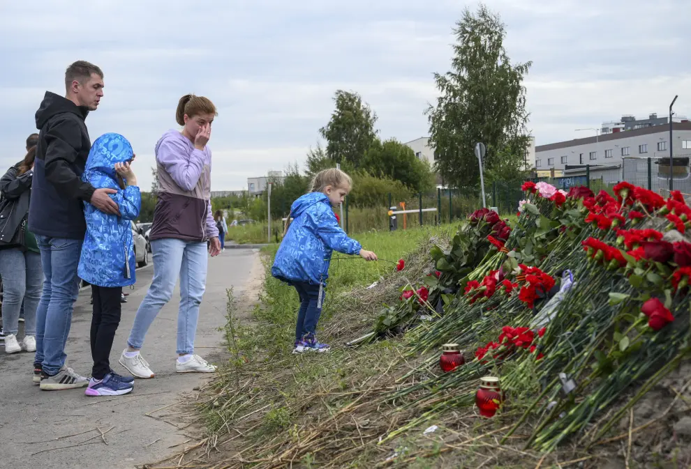 Rusos llevan flores en un monumento conmemorativo informal junto al antiguo 'Centro Wagner PMC' en San Petersburgo, Rusia