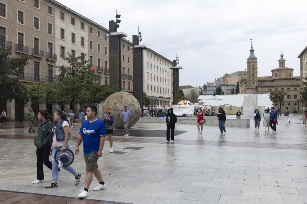 Turistas bajo la lluvia en Zaragoza en septiembre.