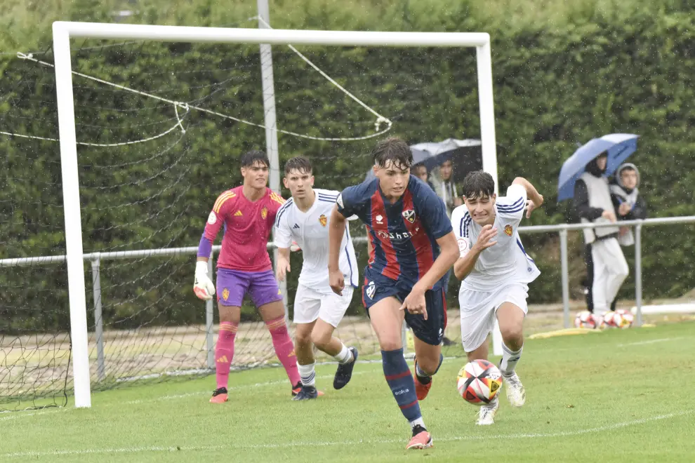 El partido entre el Huesca y el Real Zaragoza juvenil se jugó bajo la lluvia.