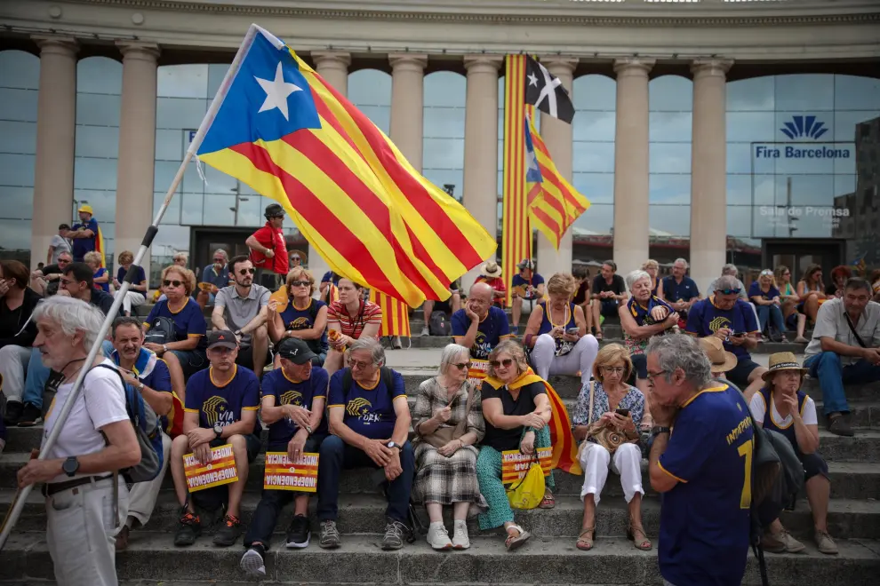 Manifestantes independentistas esperan en la plaza de España de Barcelona, al inicio del acto de la ANC por la Diada bajo el lema 'Via fora'.