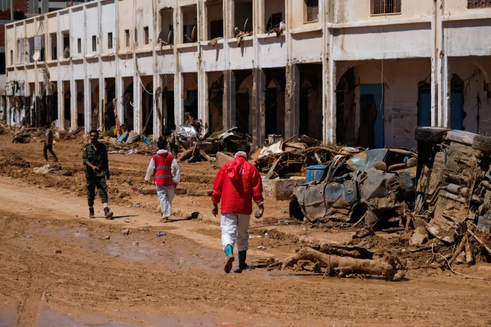Members of the Libyan Red Crescent walk between the rubbles in front of the damaged buildings, after a powerful storm and heavy rainfall hit Libya, in Derna, Libya September 13, 2023. REUTERS/Esam Omran Al-Fetori