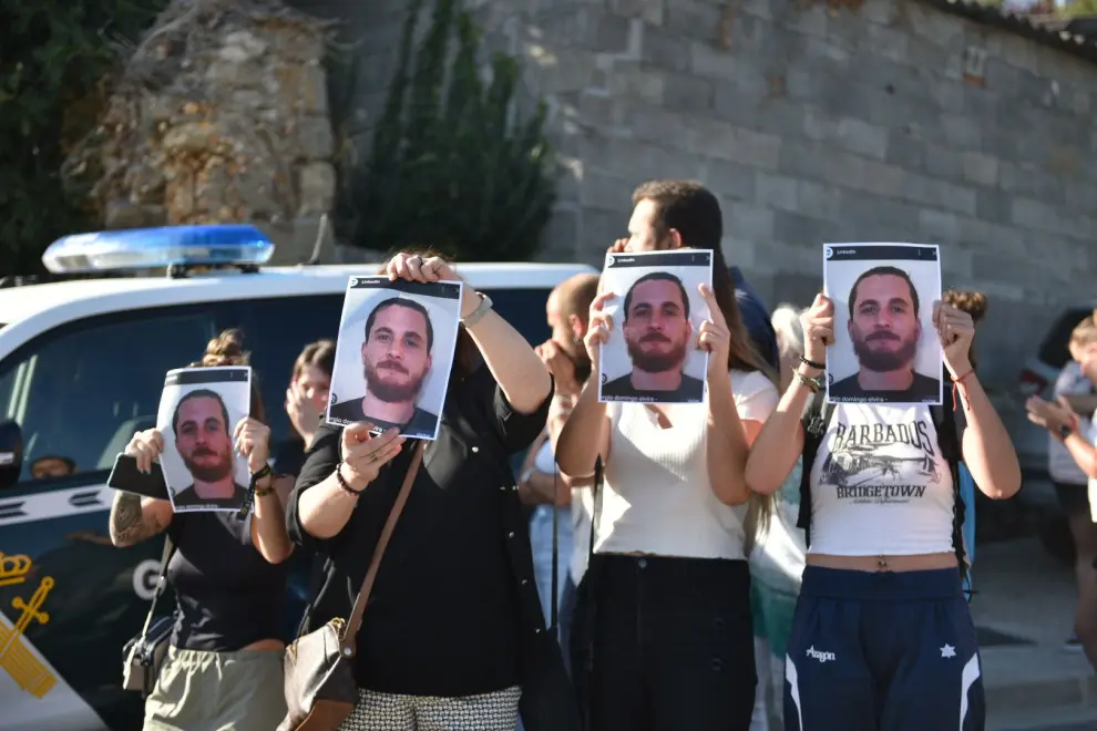 Amigos de la víctima muestran carteles con la cara del presunto homicida, al grito de "asesino", a la llegada del detenido a los juzgados de Boltaña.