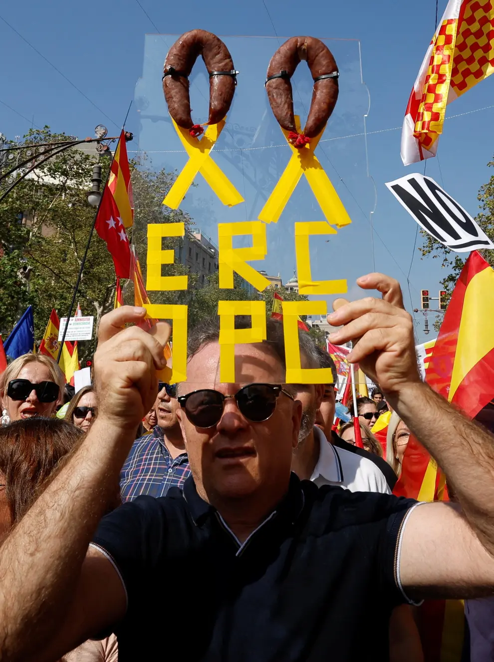 Unionist supporters protest against amnesty of separatist leaders and activists involved in the 2017 failed independence drive at Passeig de Gracia in Barcelona, Spain, October 8, 2023. The banner reads "ERC (Esquerra Republicana Catalunya) and JPC (Junts Per Catalunya) parties", with a couple of chorizos forming a ribbon. REUTERS/ Albert Gea
