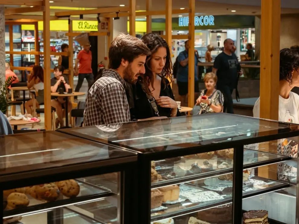 Una pareja miran alguno de los dulces de la oferta de Justicia Café.