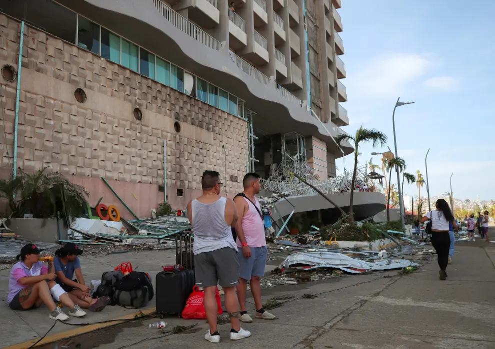 Women walk past a damaged restaurant near a beach in the aftermath of Hurricane Otis in Acapulco, Mexico, October 26, 2023. REUTERS/Henry Romero STORM-OTIS/
