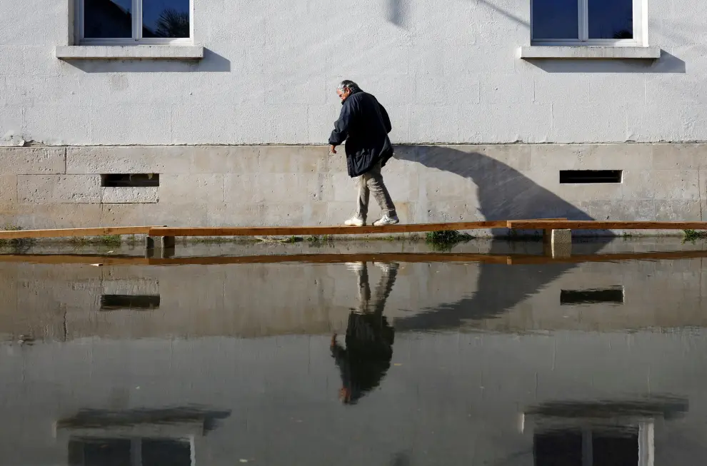 A man walks on a makeshift walkway in a flooded street as the Charente River overflows in Saintes after days of heavy rain causing flooding in western France, November 10, 2023. REUTERS/Stephane Mahe     TPX IMAGES OF THE DAY [[[REUTERS VOCENTO]]]