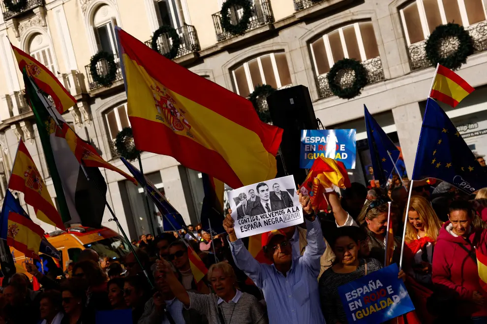 People hold flags and placards as they gather to take part in a protest called for by the Popular Party against a deal reached by Spains socialists with the Catalan separatist Junts party for government support, which involves amnesties for people involved with Catalonias failed 2017 independence bid, in Madrid, Spain November 12, 2023. REUTERS/Susana Vera [[[REUTERS VOCENTO]]] SPAIN-POLITICS/PROTESTS