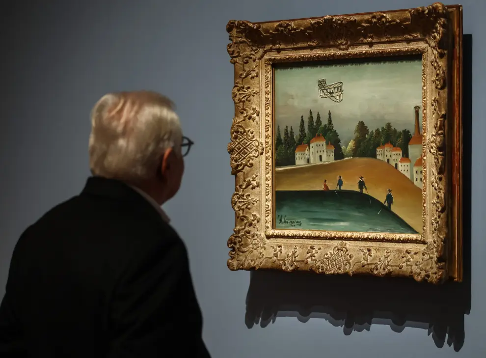 Un hombre mira una obra de arte titulada 'Los pescadores' del pintor francés Henri Rousseau