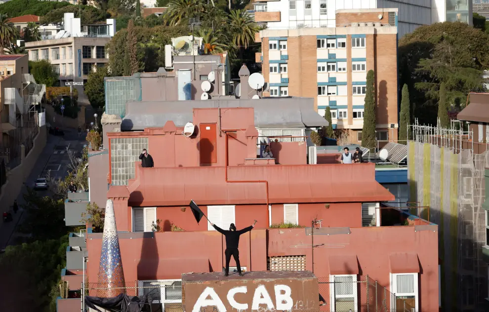 A squatter holds a black flag on a building as police officers try to evict squatted buildings of Kubo and La Ruina in Barcelona, Spain, November 30, 2023. REUTERS/Albert Gea [[[REUTERS VOCENTO]]] SPAIN-EVICTION/SQUATTERS