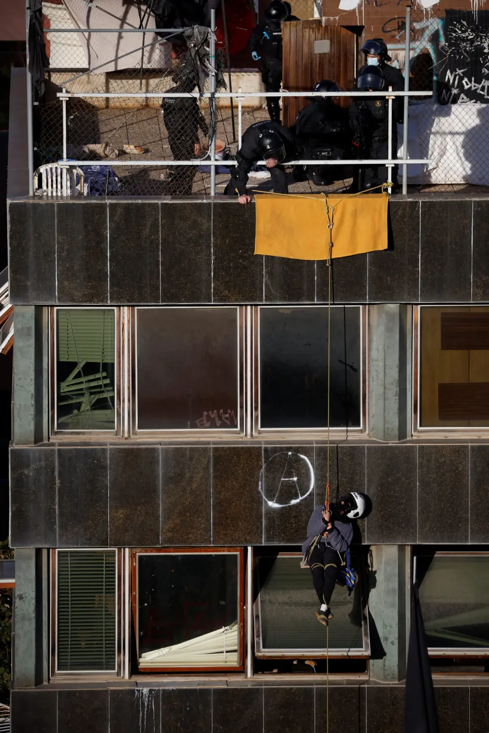 A Police officer points a gun at a squatter, as they try to evict squatted buildings of Kubo and La Ruina in Barcelona, Spain, November 30, 2023. REUTERS/Albert Gea [[[REUTERS VOCENTO]]] SPAIN-EVICTION/SQUATTERS