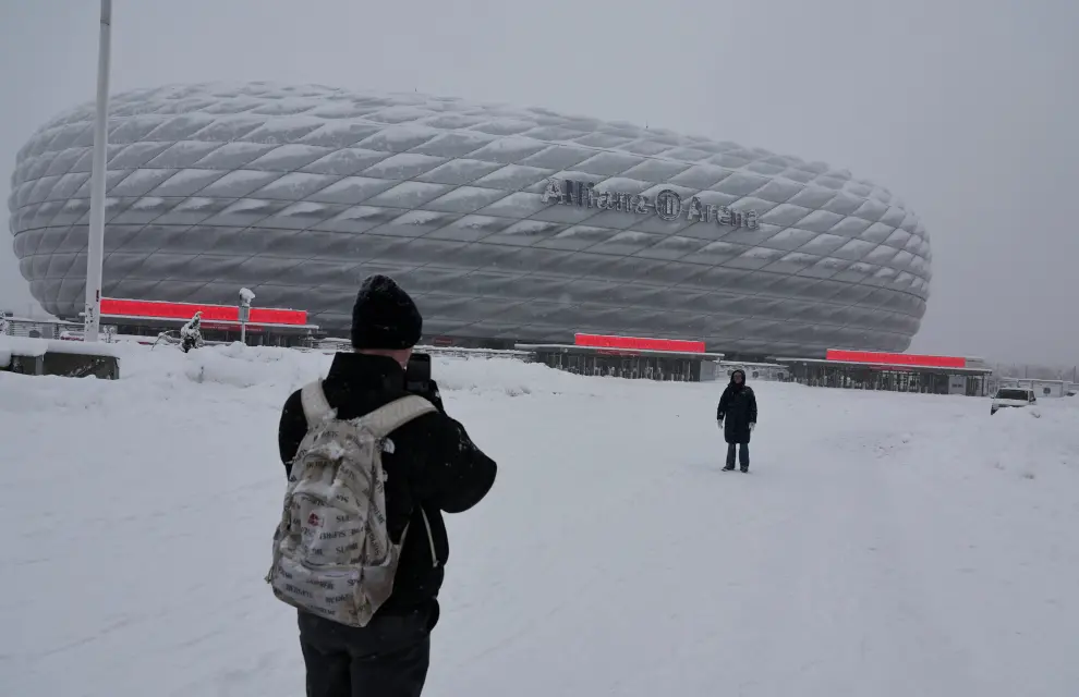 A soccer fan takes pictures of Bayern Munichs Allianz Arena which is covered in snow after heavy snowfall hit Bavaria and its capital Munich, Germany, December 2, 2023. German Bundesliga soccer match FC Bayern Munich v 1. FC Union Berlin had to be cancelled, trains halted and the airport closed because of the weather condition.      REUTERS/Leonhard Simon [[[REUTERS VOCENTO]]] EUROPE-WEATHER/GERMANY-SNOW
